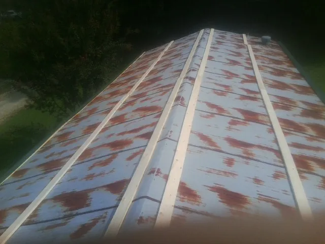 Rusted metal roof panels with new wood purlins before replacement — Storm Damage Roof Repair in Sun City by Roofing Brothers